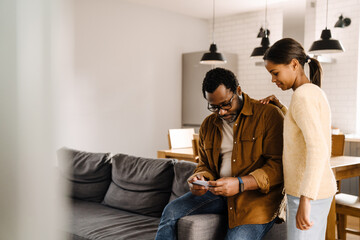 Black girl and her father talking and using cellphone