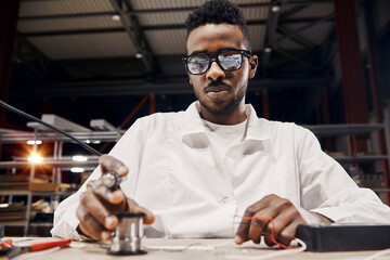 Wall Mural - african engineer using soldering iron at factory