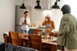 © Drobot Dean - Mature three women talking and laughing while having dinner in kitchen