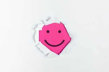 Wall Mural - Smiling happy face under a torn paper, positive emotions, good customer feedback, laughing