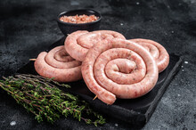 Traditional Raw Spiral Sausages On A Marble Board With Thyme. Black Background. Top View