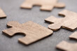 © Sensay - Creative idea and solve the problem concept. Teamwork success strategy - wooden puzzle on the grey background