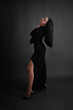 © Olena Vasylieva - a girl in a black dress with black hair on a black background. vertical
