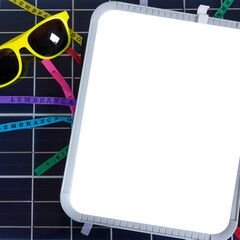 Wall Mural - Photovoltaic solar panel with Brazilian carnival elements. Solar plate with glasses, lucky bracelets, hat and carnival necklace isolated on white background.