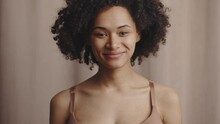 Happy Mood. Portrait Of Young Curly African American Woman Laughing Loudly To Camera, Beige Background, Slow Motion