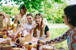 © Daniel Gonzalez/Stocksy - Positive young friends laughing during picnic