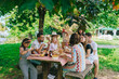 © Daniel Gonzalez/Stocksy - Friends with children chatting during picnic