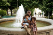 © Jelena Markovic/Stocksy - Young father playing with kids by fountain