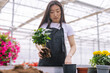 © Oleksii Syrotkin/Stocksy - Girl replunting flowers inside of greenhouse