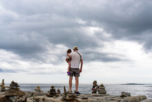Father & Child Looking At Ocean On The Coast Of Maine 