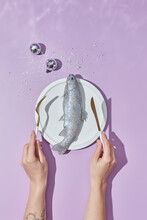 Woman Holding Fork And Knife Near Glittered Fish