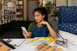 © Valentina Barreto/Stocksy - Crafswoman checking phone in living room