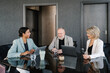 © Alina Hvostikova/Stocksy - Positive multiracial coworkers talking in office