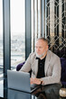 © Alina Hvostikova/Stocksy - Elderly pensive businessman using laptop
