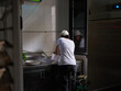 © Miquel Llonch/Stocksy - Employee washing dishes in a  professional kitchen