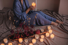 Anonymous Woman Sitting On Floor With Candles 