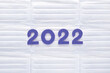 Violet felt new year numbers 2022 on white medical masks background. Inspired by trendy very peri color of the year 2022. Place for your text here.