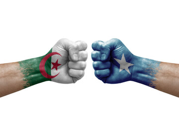 Two hands punch to each others on white background. Country flags painted fists, conflict crisis concept between algeria and somalia