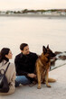© Mauro Grigollo/Stocksy - People with their dog enjoying sunset outdoor