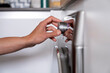 © Albert Martinez/Stocksy - hand of a person turning on a domestic appliance