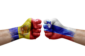 Two hands punch to each others on white background. Country flags painted fists, conflict crisis concept between andorra and slovenia