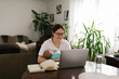 © STUDIO TAURUS/Stocksy - Smiling mom holding baby and FaceTiming via laptop