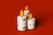 © Giada Canu/Stocksy - Cartoon xmas candles on a red background. front view