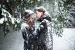 © Alina Miluseva/Stocksy - Young couple laughing covered with snow under the trees