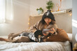 © Luis Velasco/Stocksy - Asian Woman Laying On The Bed And Reading With Her Dog.