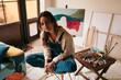 © Lucas Ottone/Stocksy - Young artist in her art studio