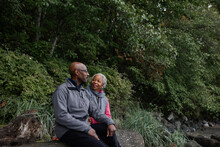 Older Couple Sitting Together Outside In Nature.