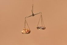 Golden Scales With Pile Of Coins And Walnuts