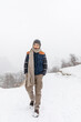 © Michela Ravasio/Stocksy - Young man walking under the snow