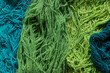 © Shava Cueva/Stocksy - texture of dyed threads in green color for rugs