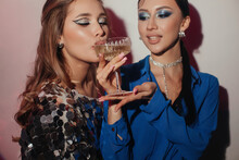 Woman Giving Glass Of Champagne To Her Girlfriend