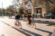 © Igor Kardasov/Stocksy - Friends riding wooden bicycles on city street