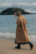 © Olga Moreira/Stocksy - Full body shot of a woman walking by the sea in winter