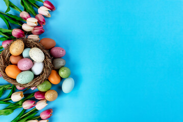 Sticker - Tulip flowers and nest plus colorful eggs on a sky blue background for the Easter holiday season