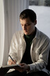 © Olga Kozicka/Stocksy - Man Writing In Journal With AirPods In His Ears