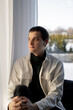 © Olga Kozicka/Stocksy - Man Listening To Music And Looking Through Window