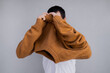 © Olga Kozicka/Stocksy - Pulling Sweater Over Head