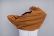 © Olga Kozicka/Stocksy - Pulling Sweater Over Head