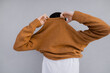 © Olga Kozicka/Stocksy - Pulling Sweater Over Head