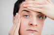 © Olga Kozicka/Stocksy - Man Hydrating Face With Lotion