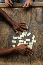 Two Unrecognizable Hands Shuffle The Dominoes