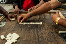 Friends Playing Dominoes On A Wooden Table.