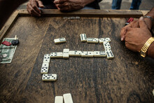 Friends Playing Dominoes On A Wooden Table.