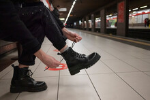 Woman Ties Boots In The Subway.