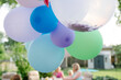 © Gabriel (Gabi) Bucataru/Stocksy - Colorful ballons at a backyard party