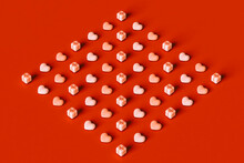  3D Hearts And Pink Gifts Organized On Red Background.